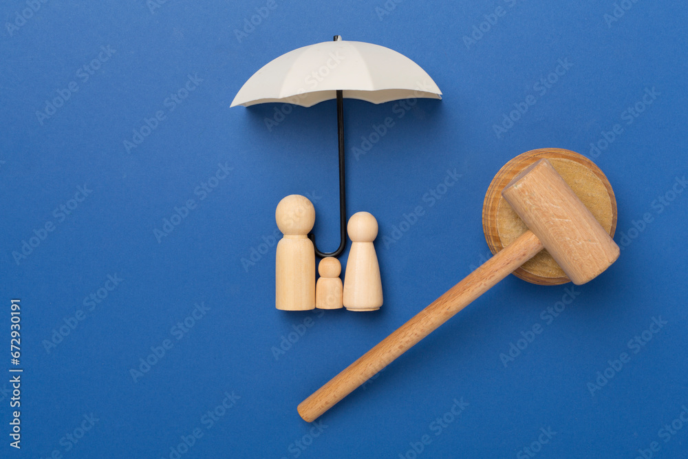 Wooden family figures with judge's gavel on color background,top view Wooden family figures with judge's gavel on color background,top view