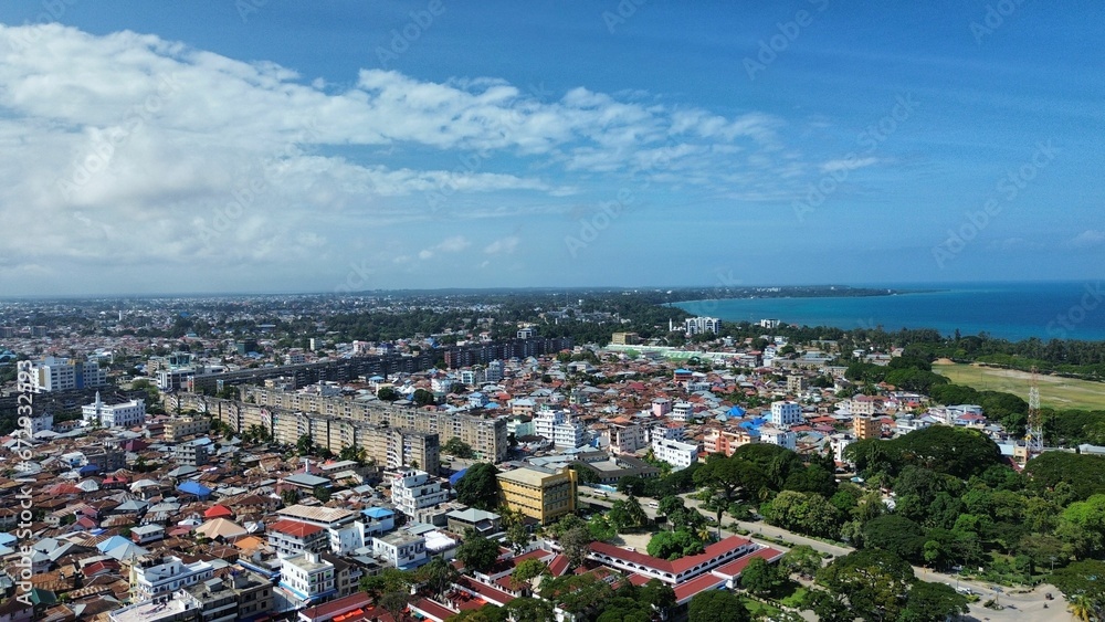 Aerial view of a cityscape against the sea on a sunny day