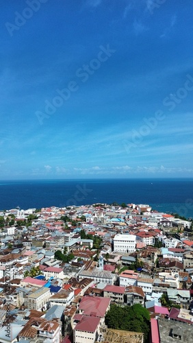 Aerial view of a cityscape against the sea on a sunny day