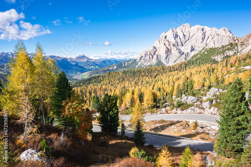 Stunning view over golden larch forests from Valparola Mountain Pass in the direction of Val Badia in the Dolomites of Italy