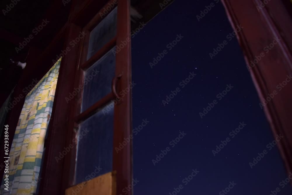Time-lapse view of the starry sky seen through an old wooden window Time-lapse view of the starry sky seen through an old wooden window