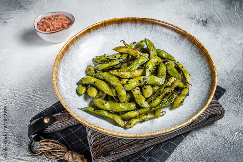 Spicy grilled Edamame Soy Beans with sea salt  in a plate. White background. Top view