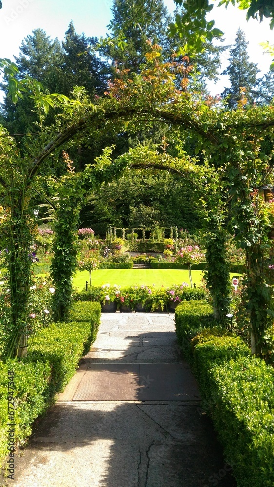 Gate leading to a lush outdoor garden space surrounded by vibrant blooms in various hues