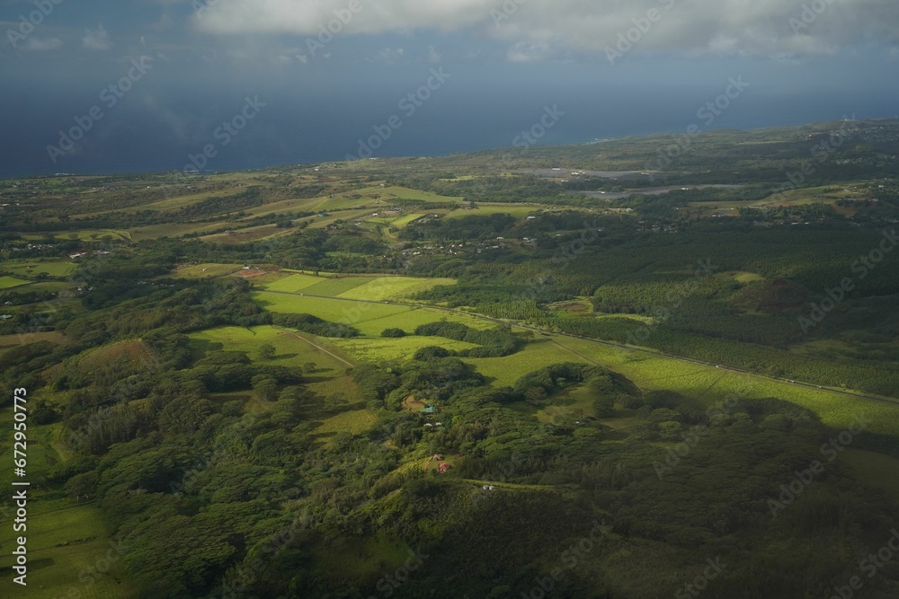 Obraz premium Aerial view of greenery under a cloudy sky on a gloomy day in Hawaii