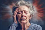 A gray-haired woman holds her head in pain. Headache, ringing in the ears, blood pressure. Precursors of stroke.