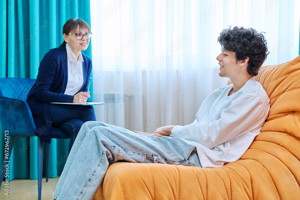 Young guy in therapy discussing his problems with female psychotherapist Young guy in therapy discussing his problems with female psychotherapist
