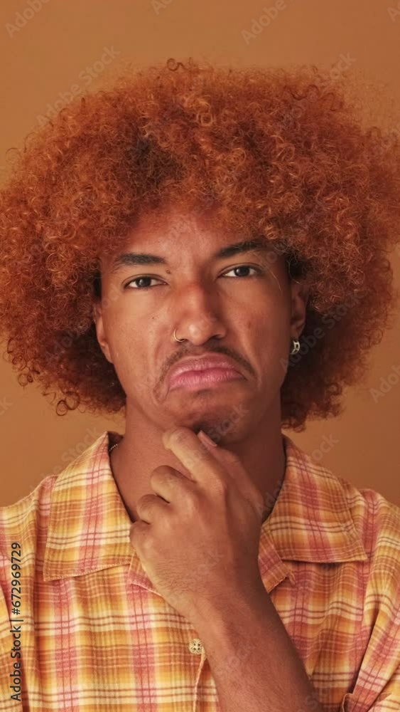 Close up, guy thinks something, makes a decision isolated on brown background in studio Close up, guy thinks something, makes a decision isolated on brown background in studio
