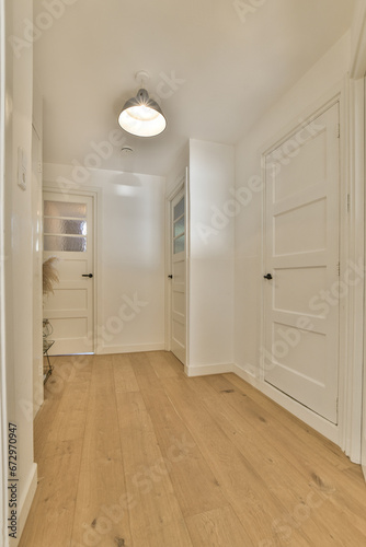 an empty room with white walls and wood flooring on the left side of the room  there is a door to the right