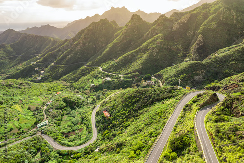 Aerial view of green volcanic landscape with mountain road in Tenerife