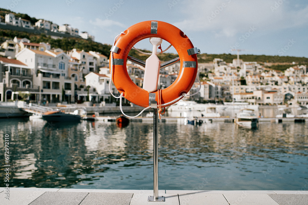 Lifebuoy on a stand with a latch stands on a pier in Lustica Bay. Montenegro