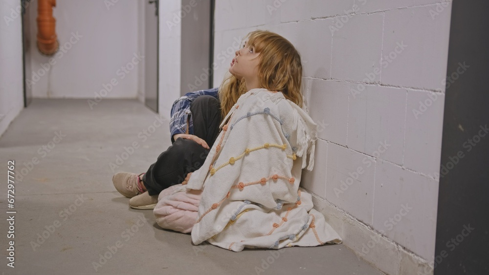 Two Scared Cowering Young Children Girls Hiding in Basement Shelter during Bombing Air Raid Bombardment Two Scared Cowering Young Children Girls Hiding in Basement Shelter during Bombing Air Raid Bombardment