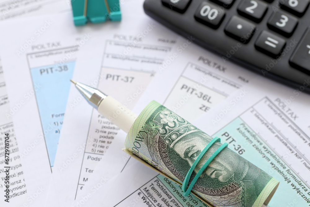 Declaration of the amount of earned income or incurred loss, PIT-36, PIT-36L, PIT-37 and PIT-38 tax forms on accountant table with pen and polish zloty money bills close up Declaration of the amount of earned income or incurred loss, PIT-36, PIT-36L, PIT-37 and PIT-38 tax forms on accountant table with pen and polish zloty money bills close up