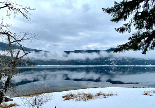Snowy lake with a layer of fog in Winter