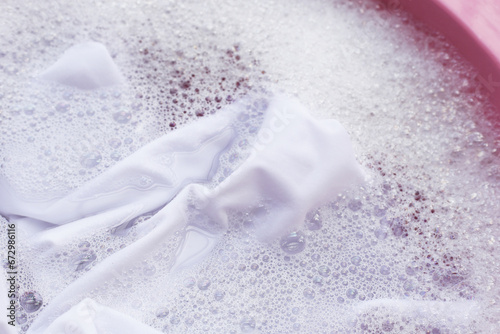 Laundry concept, white shirt soaking in water with detergent water dissolution, washing cloth photo