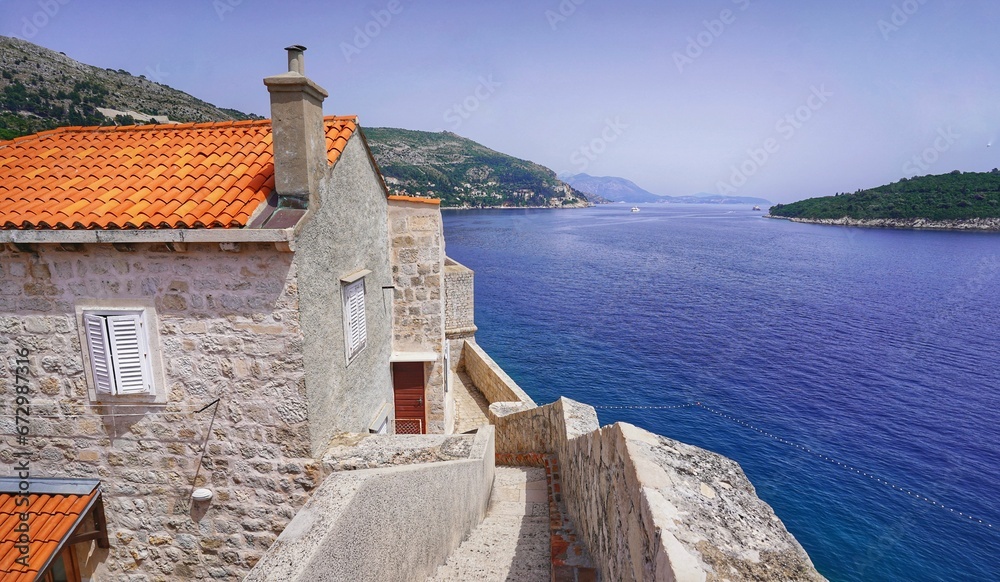 Traditional stone house against the background of the blue sea and sky. Dubrovnik, Croatia.