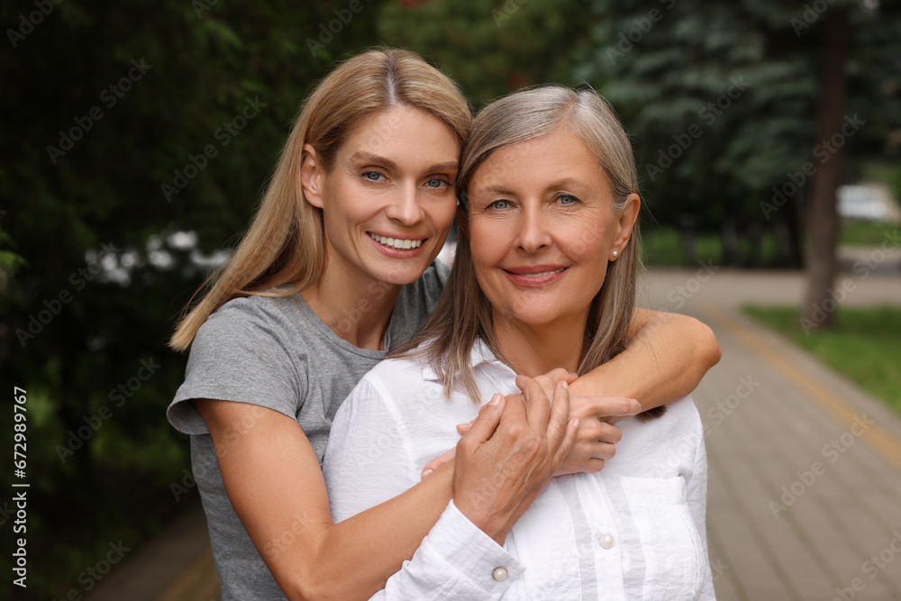 Happy mature mother and her daughter outdoors