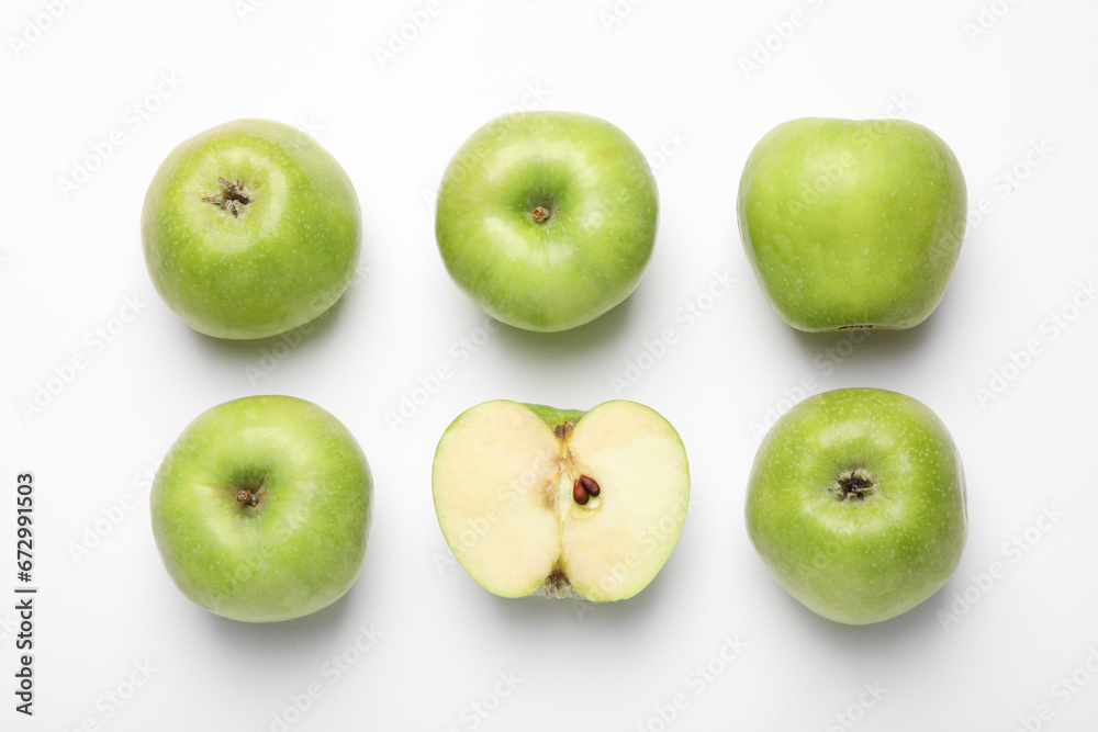 Whole and cut green apples on white background, flat lay