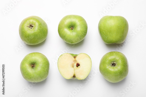 Whole and cut green apples on white background, flat lay