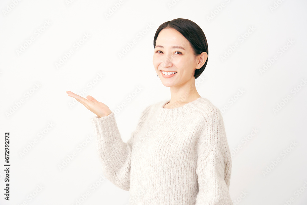 手のひらで左方向を指す中年女性 白背景 手のひらで左方向を指す中年女性 白背景