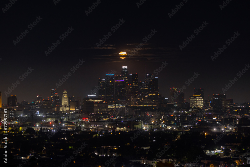 The full moon setting behind downtown Los Angeles