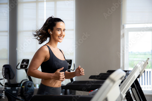 Young woman workout with jogging and exercise on machine treadmill in fitness gym sport, woman exercise with cardio training jogging, healthcare and motivation, leisure and health for strength.