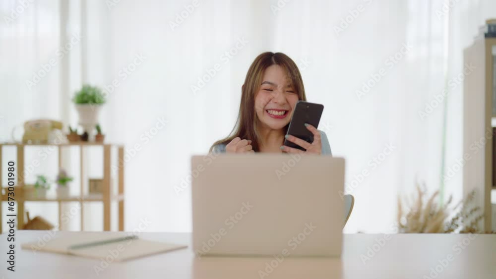 Funny euphoric young asian woman celebrating winning or getting ecommerce shopping offer on computer laptop. Excited happy girl winner looking at notebook celebrating success Funny euphoric young asian woman celebrating winning or getting ecommerce shopping offer on computer laptop. Excited happy girl winner looking at notebook celebrating success