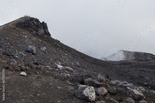 Severe mountain landscape. View of the top of the volcano. Rocks on the rim of a volcanic crater. Travel, tourism and hiking on the Kamchatka Peninsula. Gorely volcano, Kamchatka Territory, Russia. photo
