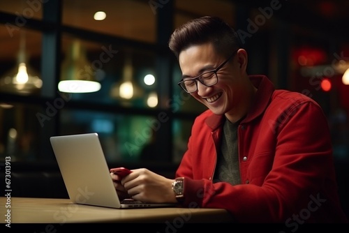 Man in stylish casual clothes using smartphone and laptop for electronic transactions, booking, online shopping. and pay while spending time at the coffee shop