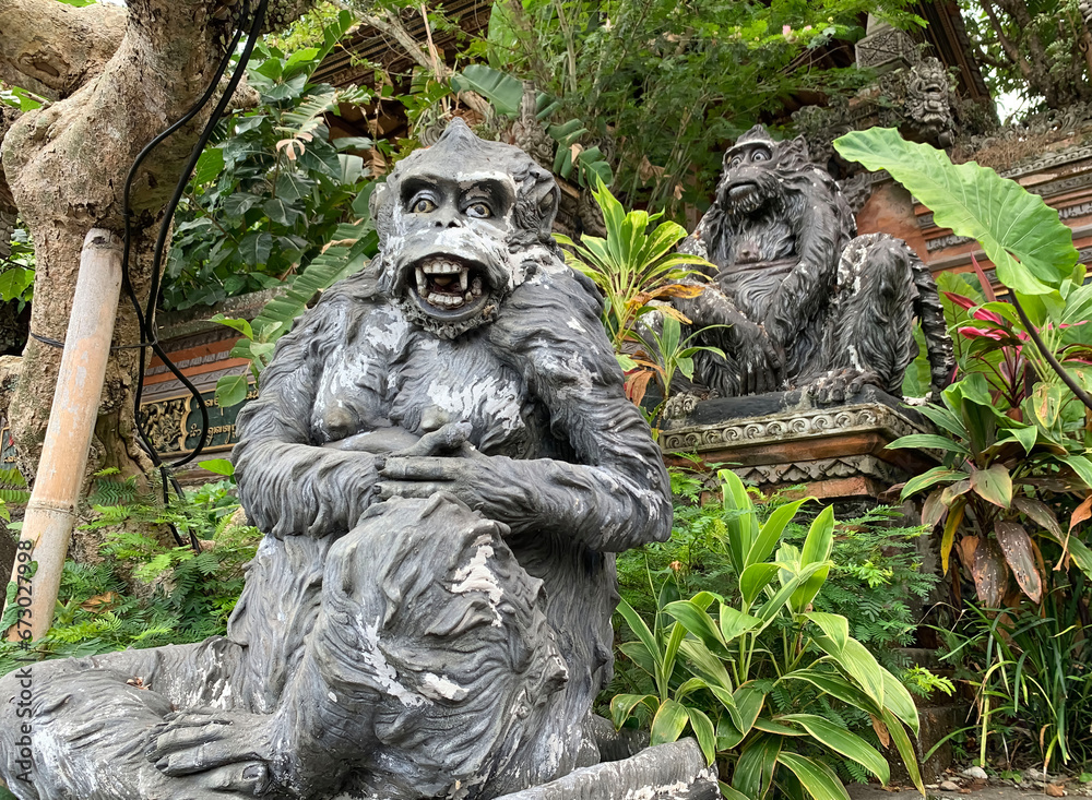 Stone monkeys statues in sacred monkey forest. Old decorative monkey sculptures in Bali ubud sacred forest