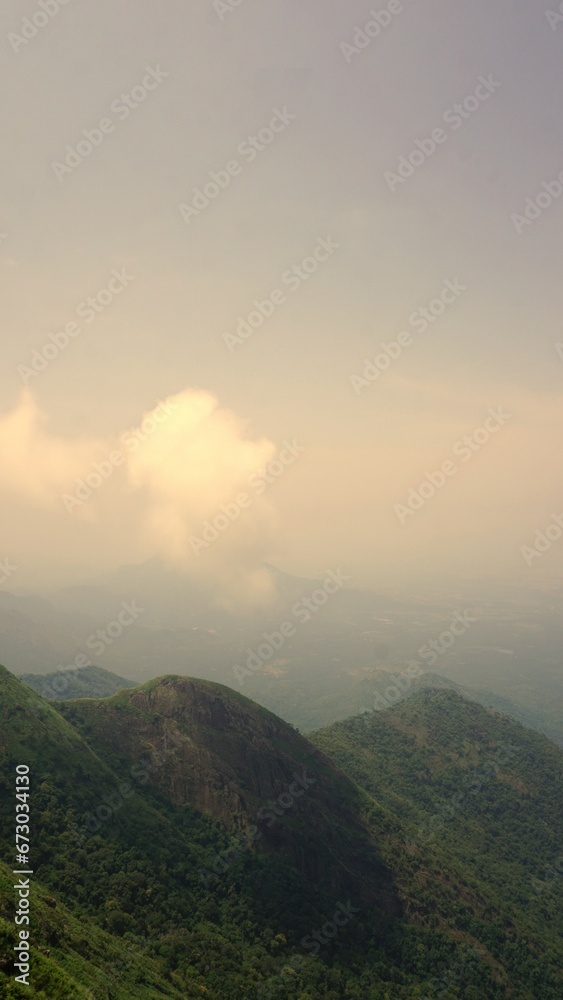 Obraz premium Beautiful dense green lush landscapes of kodaikanal hillstation filled with mist and cloudy sky.