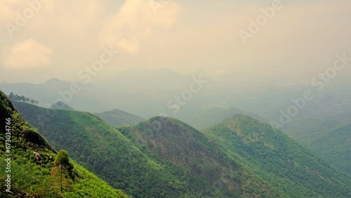 Beautiful dense green lush landscapes of kodaikanal hillstation filled with mist and cloudy sky.