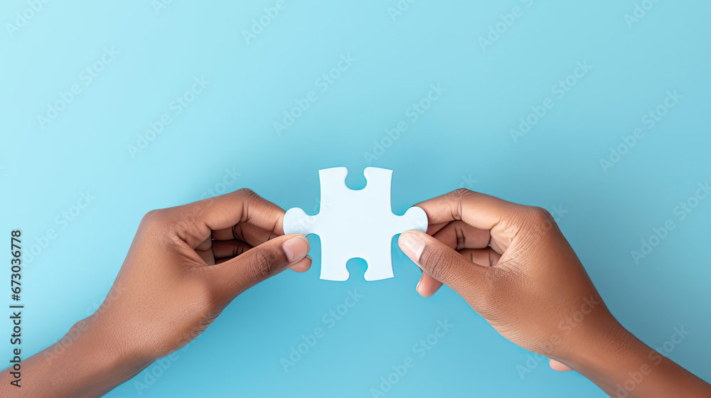Concept of business,hands holding a jigsaw puzzle on pastel blue background Concept of business,hands holding a jigsaw puzzle on pastel blue background