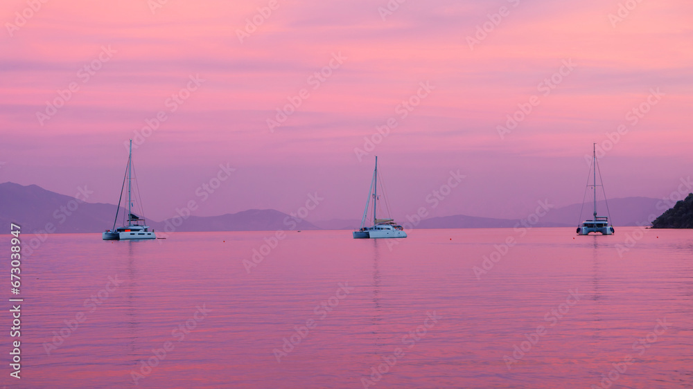 Beautiful sunset on the sea with three boats, yacht