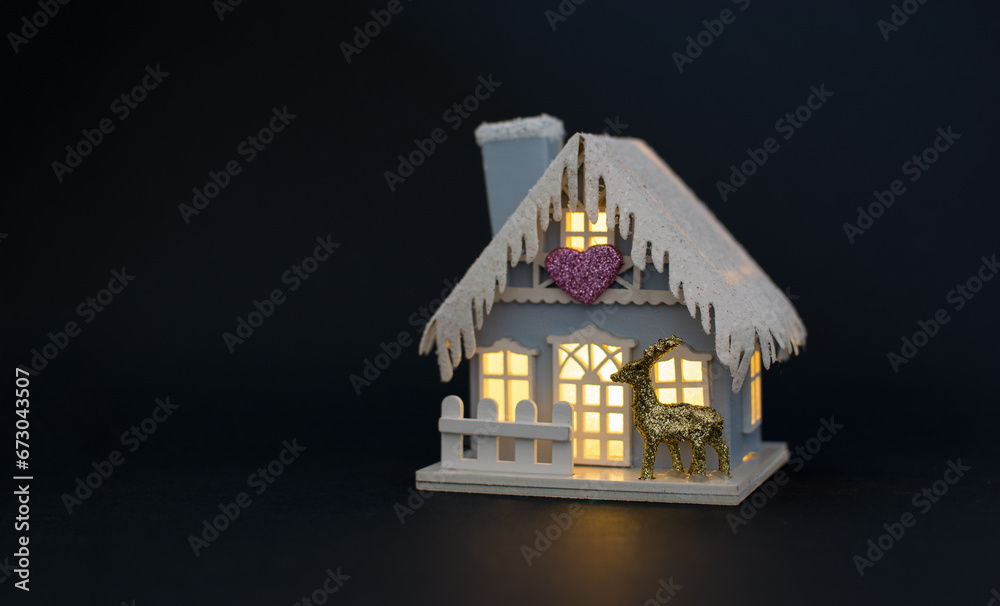 A beautiful house decorated for the New Year holidays on a black background.
