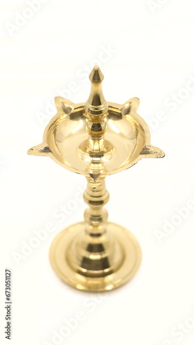 a unique, antique oil wick lamp or diya or vilakku made of brass used for rituals and worship as a tradition in hindu culture isolated in a white background