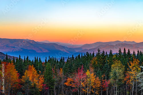 landscape of autumn mountain forest and mountain range in mist