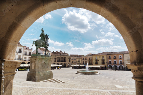 view of the main square of trujillo framed by an arch photo
