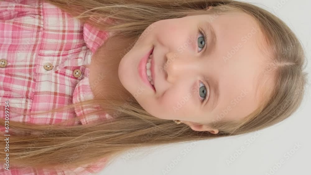 Little girl rejoices and smiles, close-up portrait. Vertical video. Little girl rejoices and smiles, close-up portrait. Vertical video.