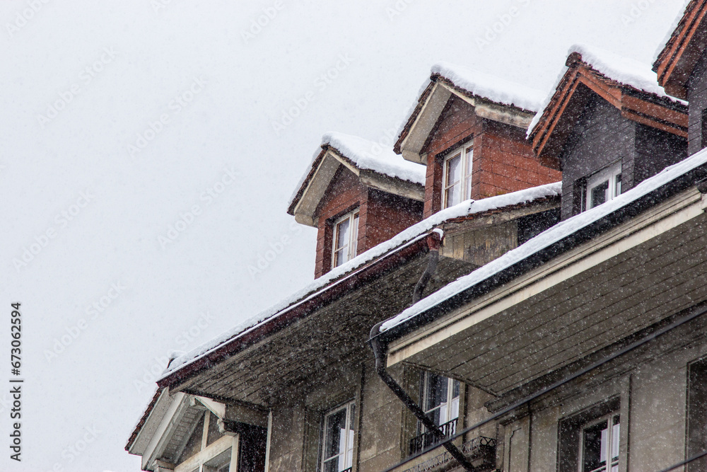 snow fall on house roof in switzerland