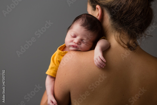 Newborn sleeping over her mother