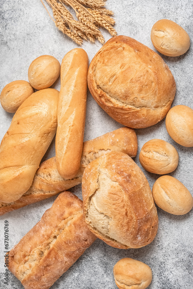 Fresh ciabatta, buns and loaf. Gray rustic background. Top view, flat lay, vertical. Selective focus.