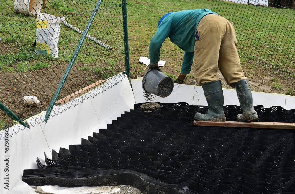Pouring crushed stone into the plastic net and compacting the plastic net with mesh