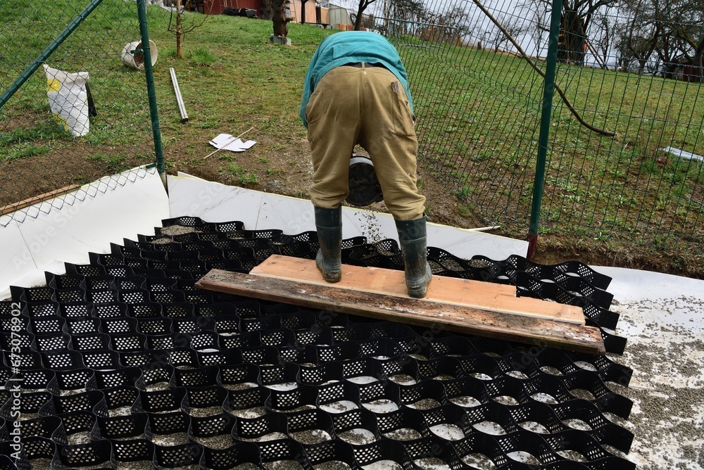 Pouring crushed stone into the plastic net and compacting the plastic net with mesh