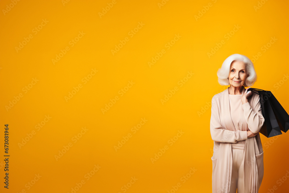 Belle femme mûre aux cheveux blancs, élégamment habillée , portant des sacs de shopping sur l'épaule sur un fond jaune moutarde avec espace texte -Shopping, black Friday, Soldes Belle femme mûre aux cheveux blancs, élégamment habillée , portant des sacs de shopping sur l'épaule sur un fond jaune moutarde avec espace texte -Shopping, black Friday, Soldes