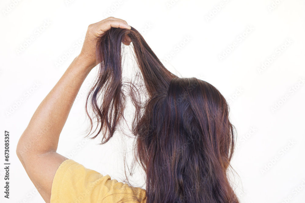 Naklejka premium Close up woman hand pulling her hair, isolated on white background. Concept, Hair pulling disorder or Trichotillomania. Mental health. Psycho problems. Itchy head.