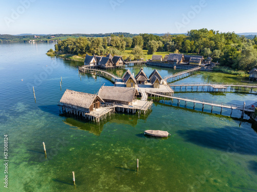 Luftbild von den rekonstruierten Pfahlbauten am Bodenseeufer, eine Touristenattraktion der Region und das älteste archäologische Freilichtmuseum Deutschlands photo