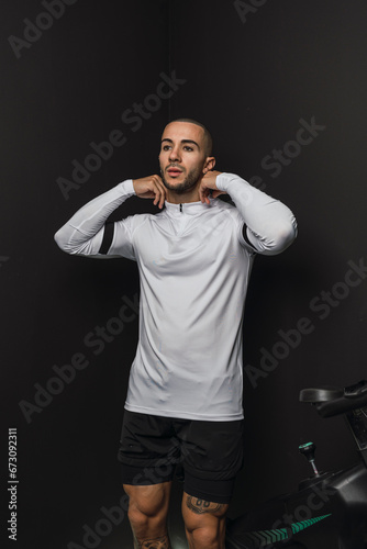 Chico joven musculado posando con ropa deportiva en gimnasio casero