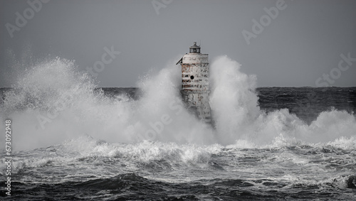 Lighthouse storm - mangiabarche lighthouse during a winter swell in Calasetta in southern Sardinia