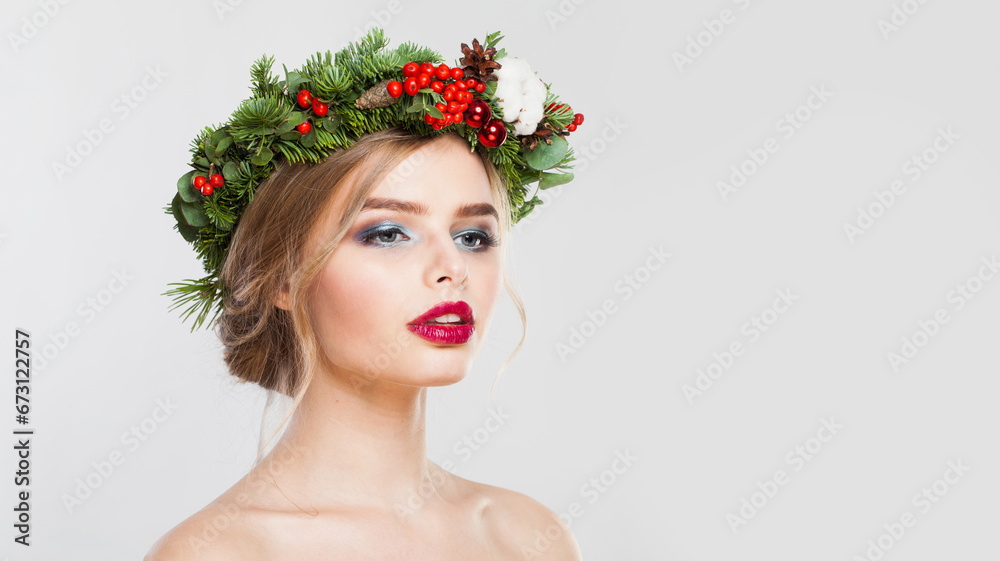 Stylish model woman with long wavy hair, makeup and colorful natural winter decoration on white studio wall background, fashion beauty portrait Stylish model woman with long wavy hair, makeup and colorful natural winter decoration on white studio wall background, fashion beauty portrait