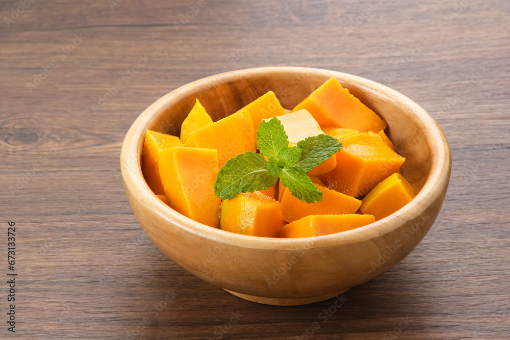 Fresh and ripe mango fruit slice on wooden bowl
Fresh and ripe mango fruit slice on wooden bowl